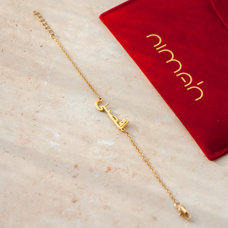 Arabic gold bracelet with a name feature design laid on a table